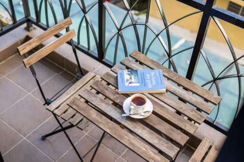 a book and a cup of coffee on a wooden bench at Serene Nova Family Retreat (2-6pax)near Kea Farm Market in Brinchang