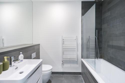 a bathroom with a sink and a toilet and a shower at The Vale - Luxury Apartments in London