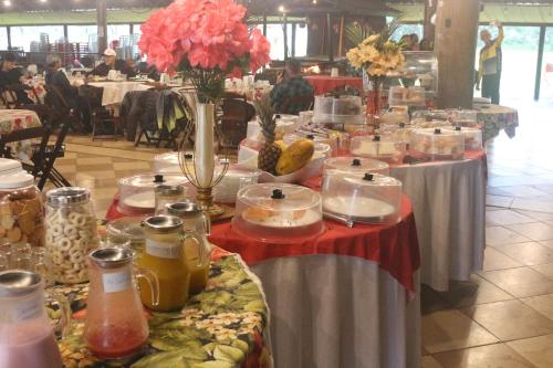 a group of tables with food and flowers on them at Pousada Rancho Texas Ubatuba in Ubatuba