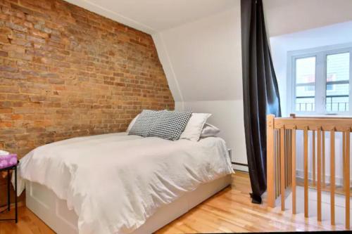 a bedroom with a brick wall and a bed at Golden Cross // Typical old Quebec appartement in Quebec City