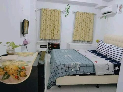a bedroom with two beds and a television in it at R2R Room in Bulanbulan