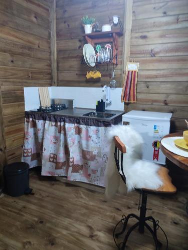 a kitchen with a counter and a chair in a room at Casa na Árvore - Chalé Quemeninho in Apiaí