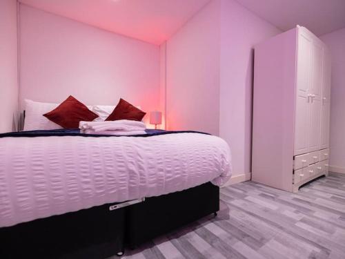 sypialnia z łóżkiem z różową ścianą w obiekcie Pristine Relocation Flat 2 w Londynie