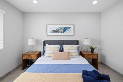 ein Schlafzimmer mit einem großen Bett mit zwei Nachttischen in der Unterkunft All Newly Renovated, 15 mins to Disney, Sleeps 8 in Santa Ana