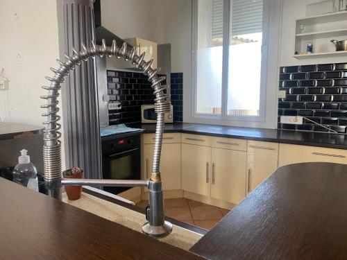 a kitchen with a wooden table with a spiral in the middle at Duplex 5, Rue Sainte Catherine in Nîmes