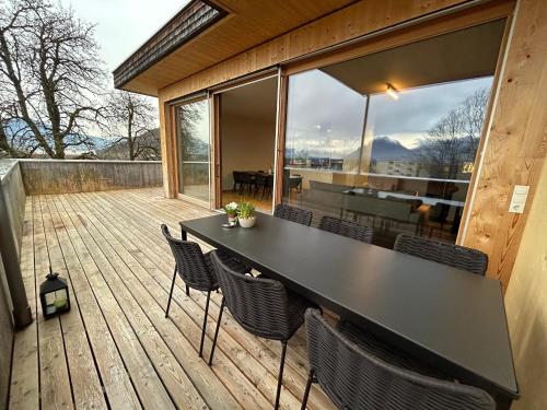 a patio with a table and chairs on a deck at Fantastische Penthousewohnung mit 100 m2 klimatisiert in Klaus