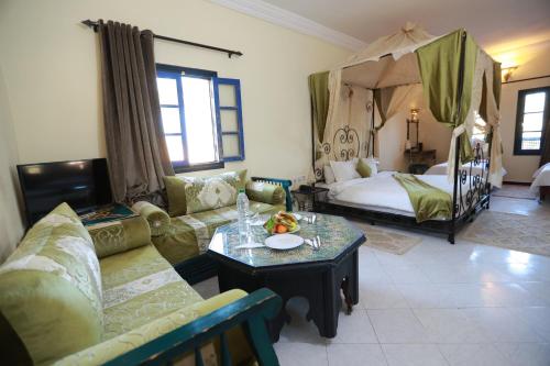 een woonkamer met een bank en een bed bij Kasbah Tizimi in Erfoud