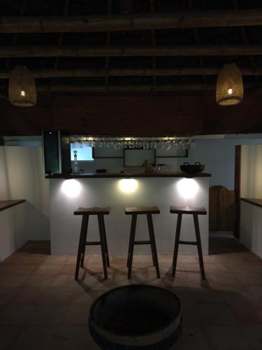 a room with two stools and a counter with lights at Casa del árbol - laVerde HABITAT 