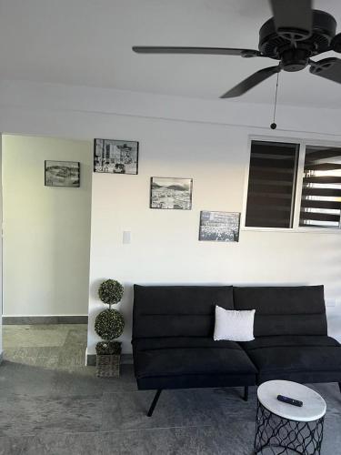a black couch in a living room with a ceiling fan at HOTEL and Suites Cananea in Cananea