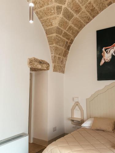 a bedroom with a stone ceiling and a bed at Palazzo Alma luxury rooms in Casarano