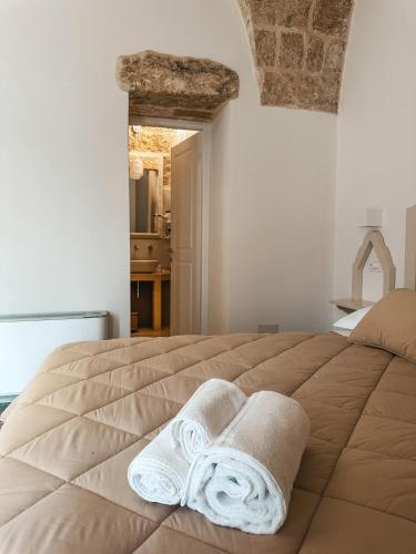 a bedroom with a large bed with towels on it at Palazzo Alma luxury rooms in Casarano
