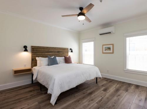 a white bedroom with a large bed and a ceiling fan at Pinewood 102 Inn At Old Beach in Virginia Beach