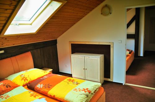 a attic bedroom with two beds and a window at Penzion Kameňák in Horní Planá