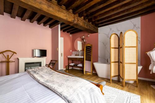 a bedroom with a large bed and a bath tub at Chez Camille in Arnay-le-Duc