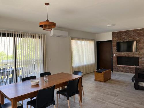a dining room with a wooden table and chairs at Viví Potrerillos in Potrerillos