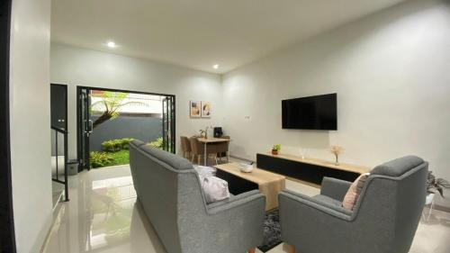 sala de estar con 2 sillas y TV en i Two Panorama Villas en Batu