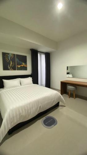 a bedroom with a large white bed and a desk at i Two Panorama Villas in Batu