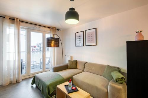 un salon avec un canapé et une fenêtre dans l'établissement Casa de Bezons - T2 de 39 m2 à 15' La Défense, proche Paris, à Bezons