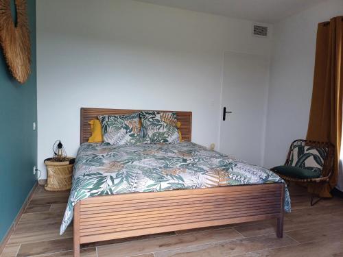 une chambre avec un grand lit avec une tête de lit en bois dans l'établissement La maison aux volets bleus, à Tresques