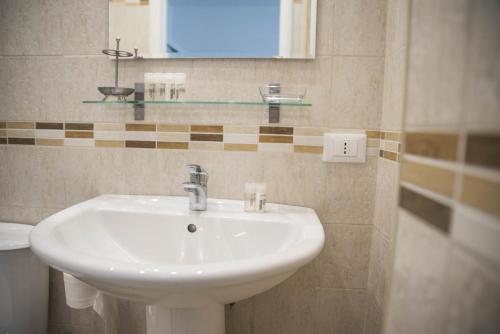 a bathroom with a white sink and a mirror at Appartamento Giovanni Verga in Mazzeo