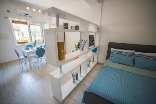 a bedroom with a bed and a table and a dining room at Appartamento Giovanni Verga in Mazzeo