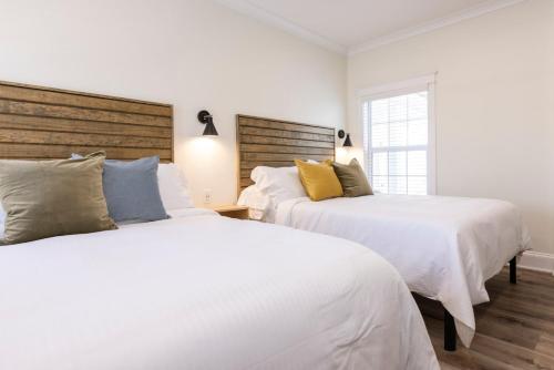 two beds in a bedroom with white walls at Newcastle 106 Inn at Old Beach in Virginia Beach