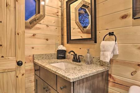 uma casa de banho com um lavatório numa cabina de madeira em Clear Blue Morning - Heated Pool & Cinema Nights em Sevierville