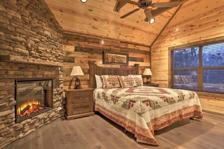 um quarto com uma cama e uma lareira num chalé de madeira em Clear Blue Morning - Heated Pool & Cinema Nights em Sevierville