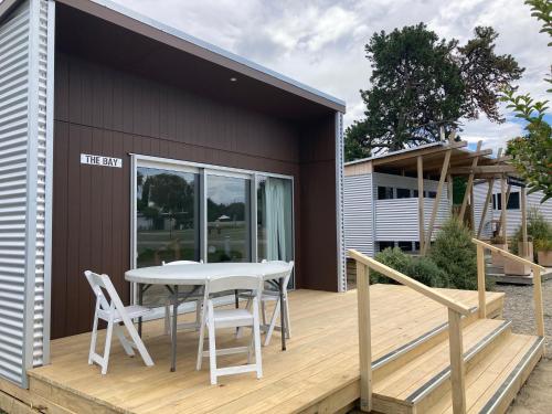 a patio with a table and chairs on a deck at Te Mata Views Resort in Havelock North