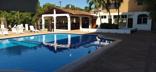 a swimming pool in front of a house at HOTEL PARAISO ESCONDIDO in Chacala