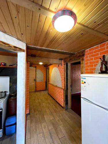 a kitchen with a white refrigerator and a brick wall at Шепіт Лісу in Yaremche
