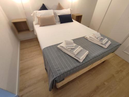 una piccola camera da letto con un letto con asciugamani sopra di Casa da Madalena a Faro