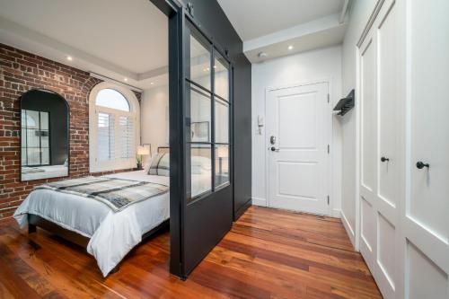 a bedroom with a bed and a brick wall at -NEW- The Rock and Red Luxury Condo in Quebec City