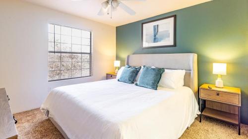 1 dormitorio con cama blanca y pared verde en Landing Modern Apartment with Amazing Amenities (ID6628X19), en Albuquerque