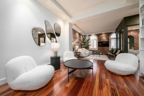 a living room with white chairs and a table at -NEW- The Rock and Red Luxury Condo in Quebec City