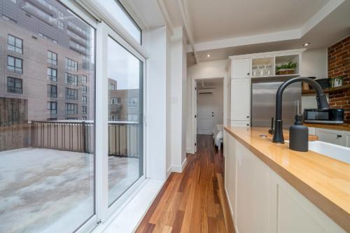 a kitchen with a balcony with a large window at -NEW- The Rock and Red Luxury Condo in Quebec City