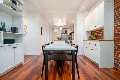 a kitchen and dining room with a table and chairs at -NEW- The Rock and Red Luxury Condo in Quebec City
