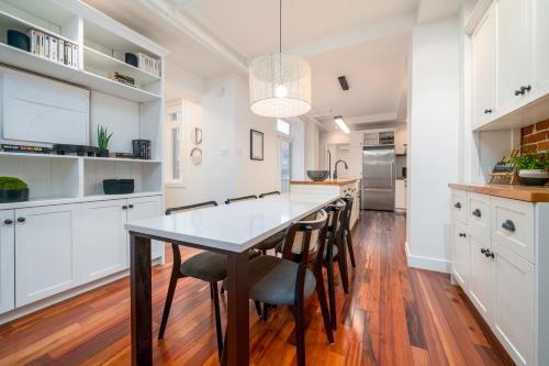 a kitchen with white cabinets and a table and chairs at -NEW- The Rock and Red Luxury Condo in Quebec City