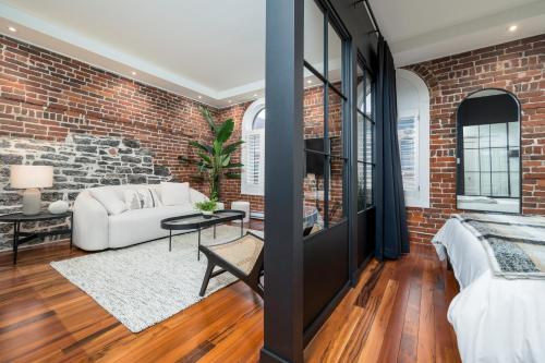 a living room with a brick wall at -NEW- The Rock and Red Luxury Condo in Quebec City