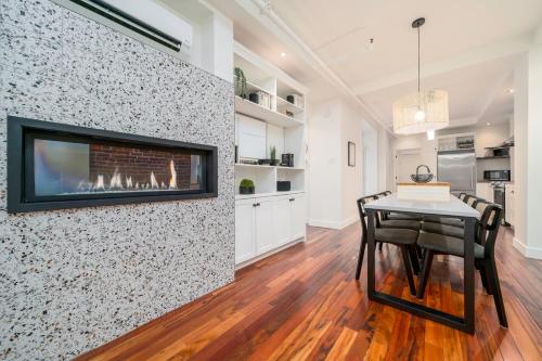 a dining room with a fireplace on a wall at -NEW- The Rock and Red Luxury Condo in Quebec City