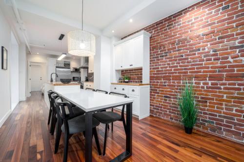 a kitchen with a brick wall and a table and chairs at -NEW- The Rock and Red Luxury Condo in Quebec City