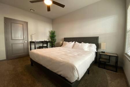 a bedroom with a large bed and two tables at KING BEDS & Patio-65 inch Roku-Walk to Food and Drinks in Fort Worth