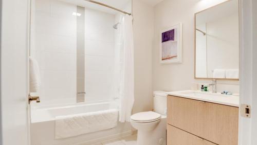 a white bathroom with a toilet and a shower at Landing Modern Apartment with Amazing Amenities (ID7709X66) in Baltimore