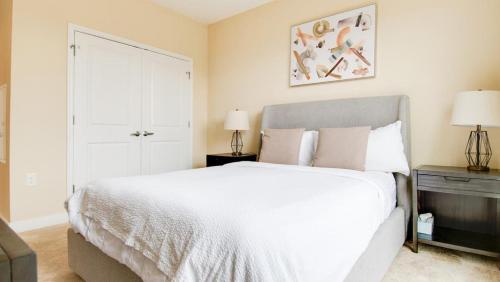 1 dormitorio con 1 cama blanca grande y 2 lámparas en Landing Modern Apartment with Amazing Amenities (ID7221X88) en Frederick