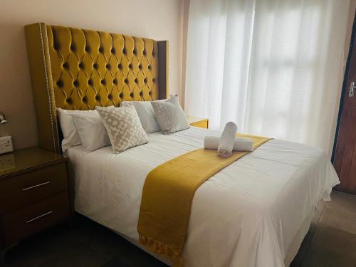 ein Schlafzimmer mit einem großen Bett mit einem großen Kopfteil in der Unterkunft Winbert Apartments in Ladysmith