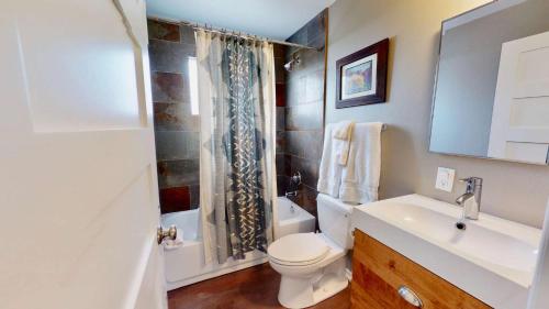 Baño blanco con aseo y lavamanos en Downtown Cozy Home Base - Purple Sage 8 en Moab
