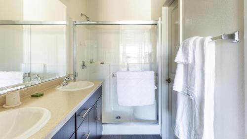 - Baño blanco con 2 lavabos y ducha en Landing Modern Apartment with Amazing Amenities (ID6986X77), en Otay Mesa