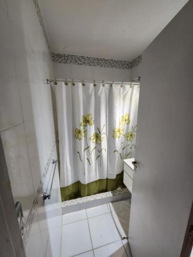 y baño con cortina de ducha y lavamanos. en Departamento Atlántico I en San Bernardo