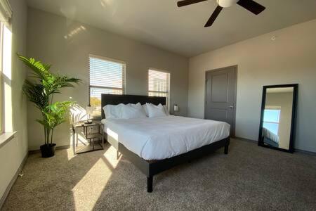 um quarto com uma cama e uma ventoinha de tecto em KING BEDS-Lg Apt-65 inch Roku-Walk to Food and Drinks em Fort Worth