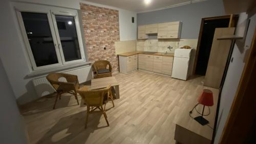 cocina con mesa, sillas y nevera en Kawalerka na wyłączność en Racibórz